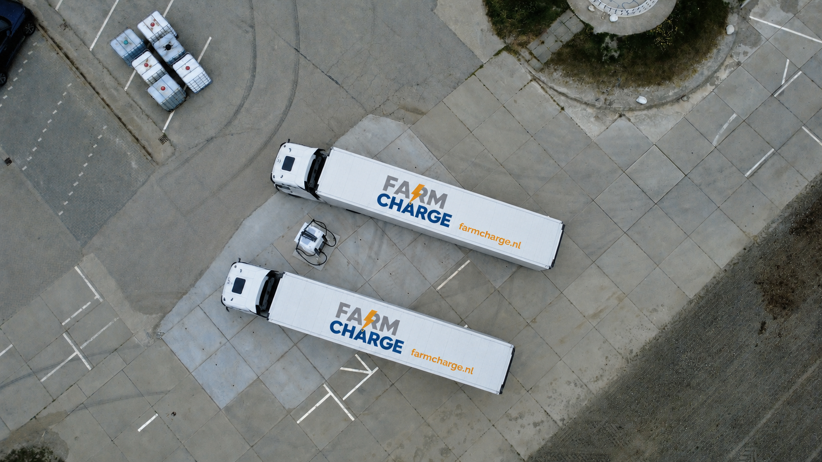 Twee Farm Charge vrachtwagens bij de snellader vanuit de lucht